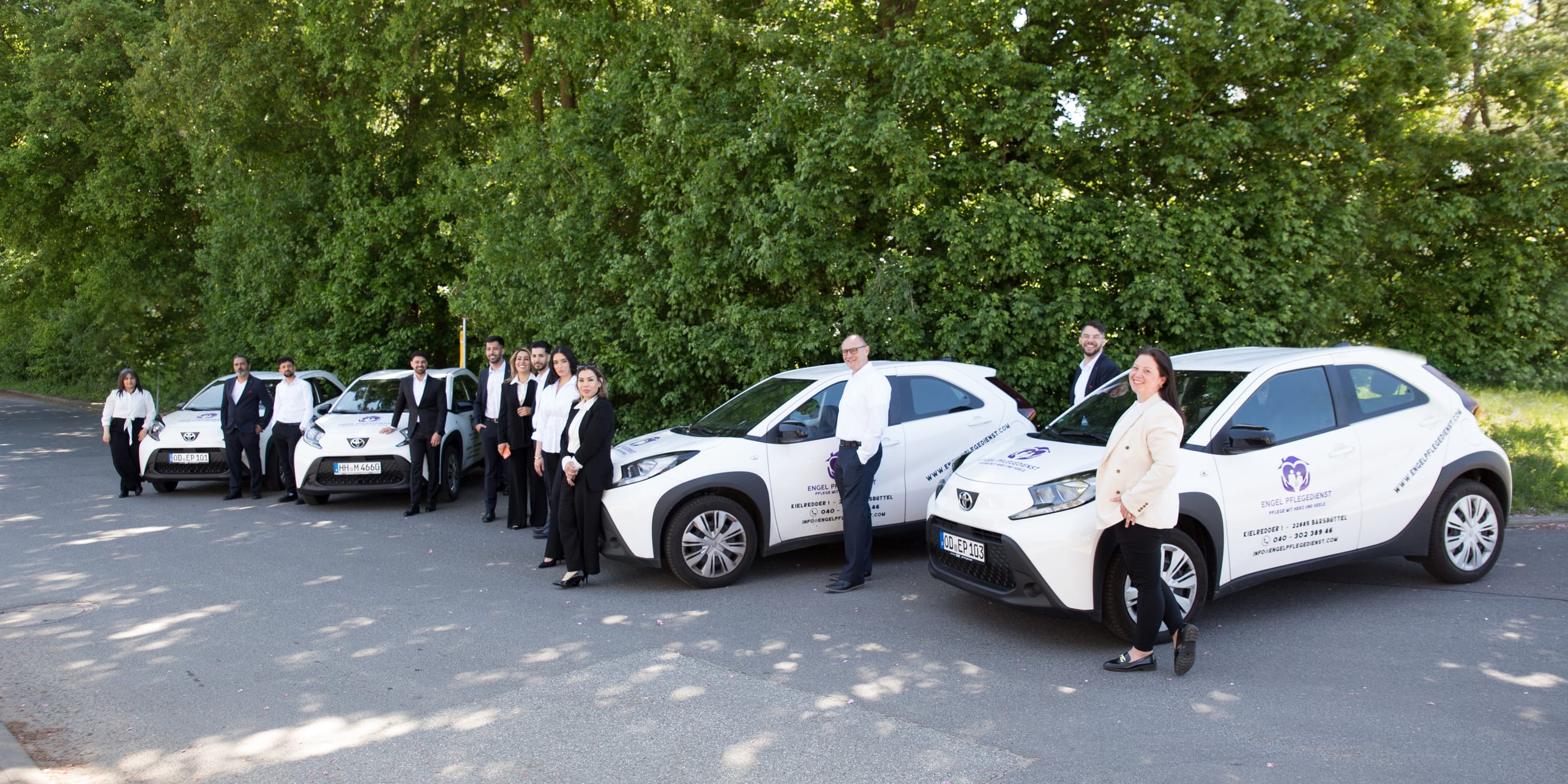 Das Team von Engel Pflegedienst mit den weißen Dienstwagen der Flotte